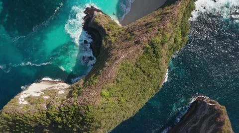 The tall elephant cliffs blocking the waves are covered with green trees and  Stock Photos