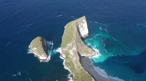 The tall elephant cliffs blocking the waves are covered with green trees and  Stock Photos