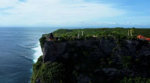 The tall elephant cliffs blocking the waves are covered with green trees and  Stock-Fotos