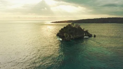 The tall elephant cliffs blocking the waves are covered with green trees and  Stock-Fotos