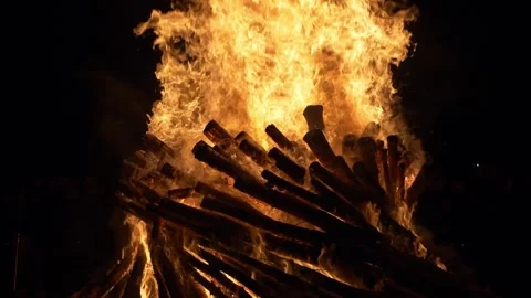 Tall flames dance around stacked logs in a powerful fiery spectacle. Slow motion Stock Footage 305746411
