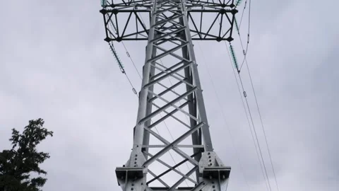 Tall high voltage electricity tower towering against a cloudy sky in the rural Vidéo 289674859