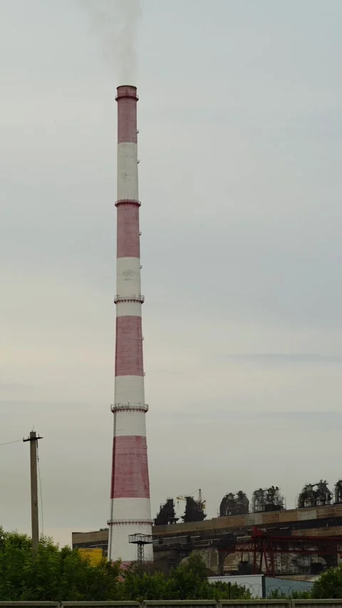 Tall industrial chimney stack emitting smoke at a factory area 库存影片 338199942