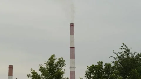 Tall industrial chimney stack emitting smoke at a factory area 库存影片 338201540