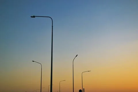 Tall lampposts against the background of a gradient evening clear sky Foto stock