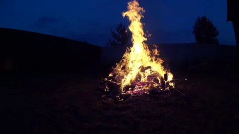 Tall Man Turning Burning Garbage In Large Bonfire on Cottage Backyard Vídeos de archivo 74979507