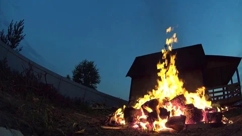 Tall Man Turning Burning Garbage In Large Bonfire on Cottage Backyard Video stock 74979739