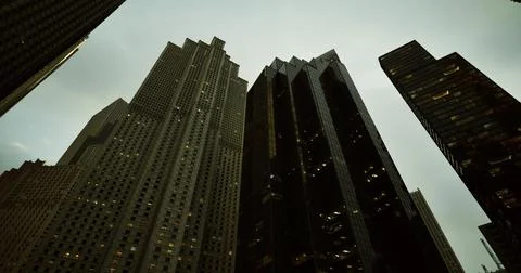 Tall modern buildings under cloudy sky in urban landscape at dusk Ilustración de archivo