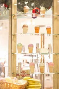 Tall open display case in cafe with lots of ice cream, christmas tree with ba Stock Photos