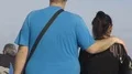 Tall overweight male walking with his arm on females shoulders, slow motion HD Footage