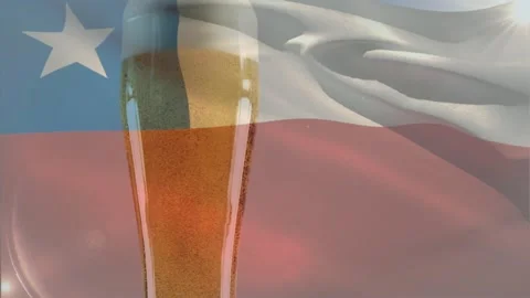 Tall pilsner glass developing foam while Chilean flag waving and sun glinting, Stock Footage 329505602