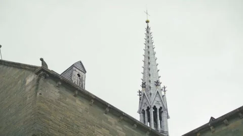 A tall, pointed building with a cross on top Stock Footage 296400988