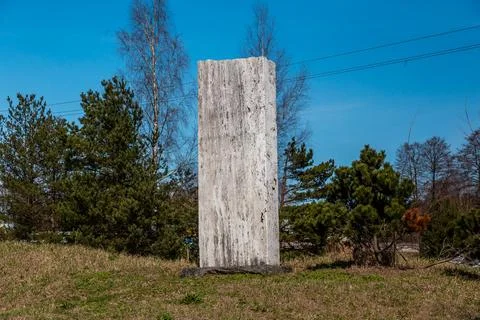 Tall Rectangular Stone Monument Amid Trees and Open Sky 스톡 사진