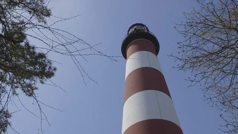Tall Red and White Lighthouse Below Clear Blue Sky Video stock 74401433