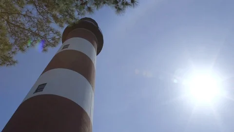Tall Red and White Lighthouse Below Clear Blue Sky On Sunny Day Vidéo 74401576