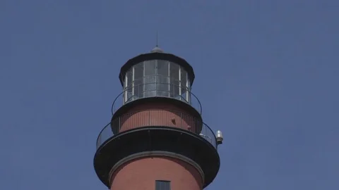 Tall Red and White Lighthouse Below Clear Blue Sky Vídeo Stock 74401903