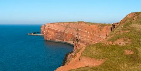 Tall red dramatic cliffs of Heligoland island with on a beautiful sunny day Stock Photos