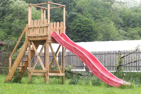 A tall red slide in the backyard Foto stock