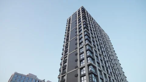 Tall residential skyscraper rises under bright sunny sky 動画素材 326474459