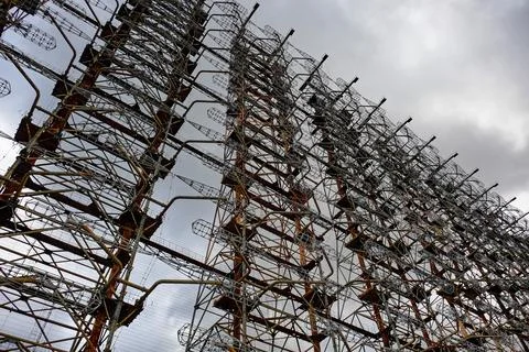 Tall rusty edifices featuring a complex network of wires. Duga Stock Photos