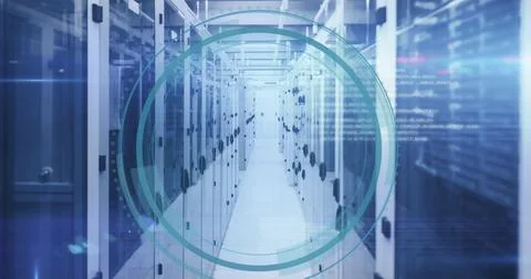 Tall server cabinets lining narrow aisle under cool blue lighting with teal Stock Photos