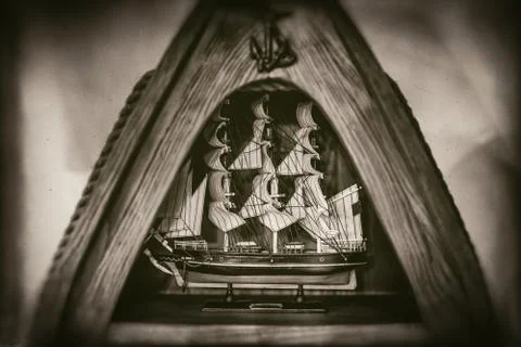 Tall ship model in triangular wooden frame on faded photo 스톡 사진
