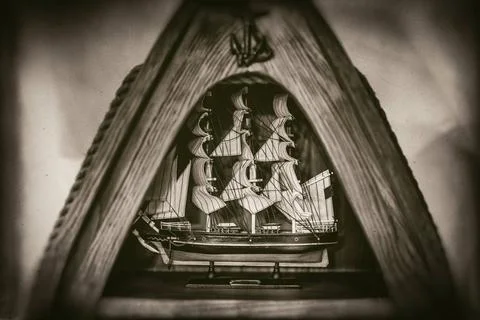 Tall ship model in triangular wooden frame on faded photo Tall ship model ... Stock Photos