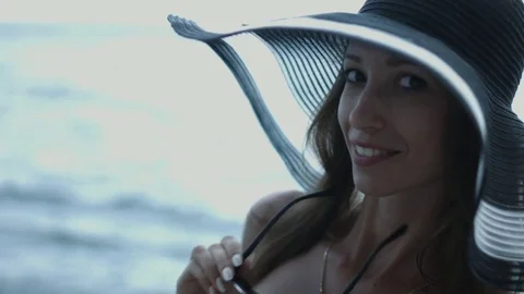 Tall slender girl in the hat and sunglasses posing while standing in the bikini Stock Footage