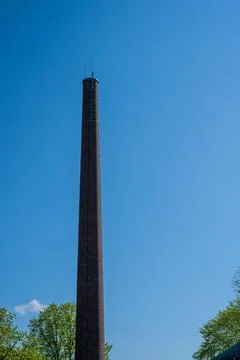 Tall smoke stack on blue sky Stock Photos