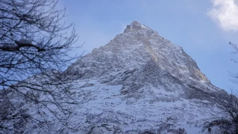 Tall snow-capped mountain peak with clear blue sky Stock Footage 310230333