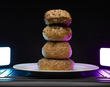 Tall stack of assorted bagels on plate with studio lighting Stock Photos