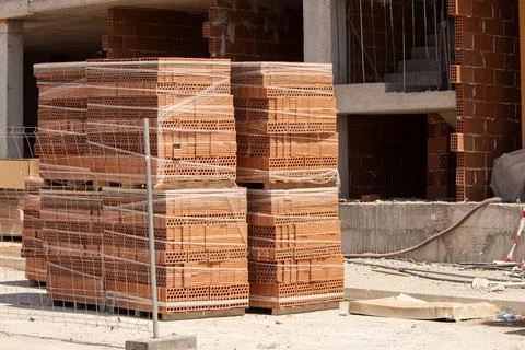 A tall stack of bricks packed on a pallet at a construction site Foto stock