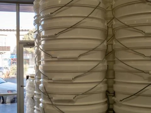 Tall stack of clean white buckets in home improvement store Stock Photos