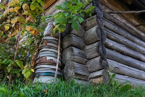 A tall stack of iron buckets stand in the corner of a wooden house Stock Photos