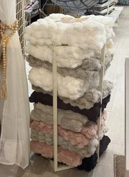 A tall stack of soft textured blankets in various colors on a retail display  Stock Photos
