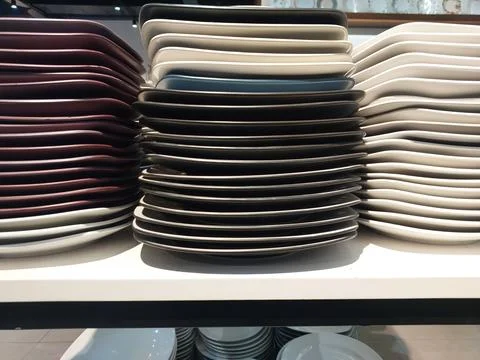 Tall Stacks of Square Ceramic Plates in Multiple Colors on Retail Shelf Stock Photos