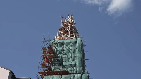 Tall structure wrapped in green mesh. The clear blue sky overhead highlights the Video stock 345885014