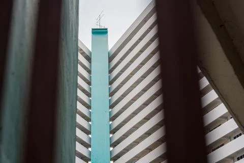 Tall teal pillar rises between concrete structures Stock Photos