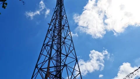 Tall Telecommunication Tower and Cellular Base Station Under Bright Sunny Sky Stock-Footage 332704164