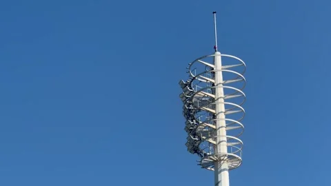 A tall tiered high-mast floodlight tower with multiple rings of stadium Stock Footage 346467014