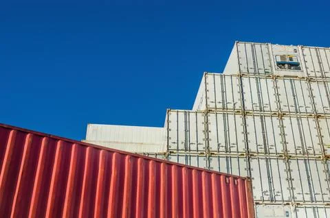 Tall wall of freight containers in front of blue sky Stock Photos