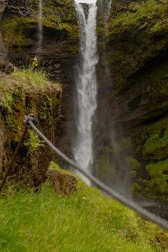 Tall Waterfall Cascading Down Moss Covered Cliff in Iceland Fotos de archivo