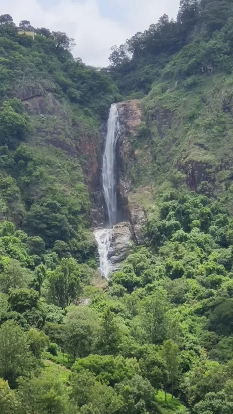 Tall Waterfall Cascading Through Lush Green Mountain Forest Stock Footage 324706949