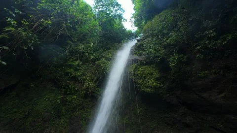 Tall waterfall flows down mossy rocks. Perfect for nature documentaries Vídeos de archivo 334628306