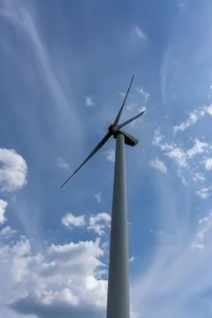 The tall windmill rotates with the force of the wind Stock Photos