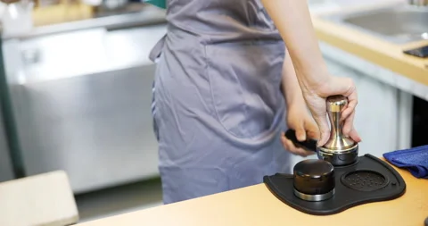Tamping fresh coffee to make ground coffee Stock Footage 172339449