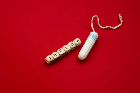 Tampon lying isolated on red background with text period. Concept women sanit Stock Photos