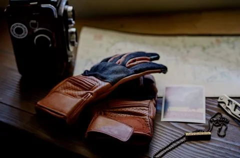 Tan motorcycle gloves on map on side angle (flatlay) Stock Photos