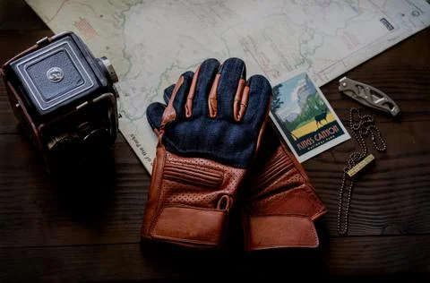 Tan motorcycle gloves on map on top down angle (flatlay) Stock Photos