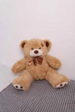 Tan teddy bear sitting front view with bow Stock Photos